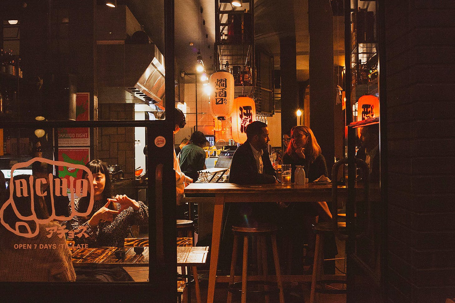 People sitting at Acho's, one of the best late-night spots on K'Road.